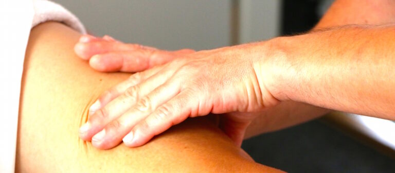 Mains réalisant un drainage lymphatique manuel sur la cuisse